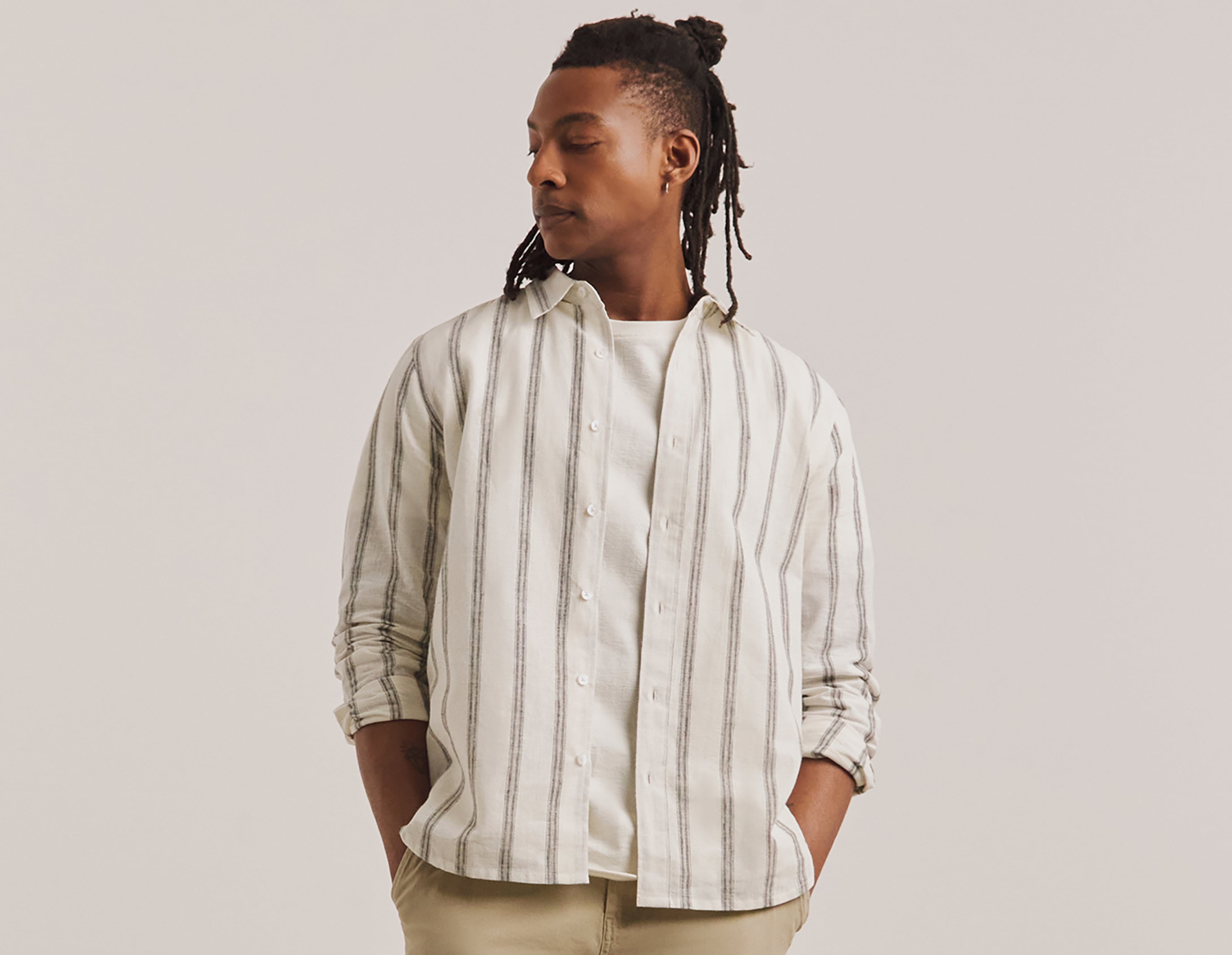 A man stood wearing a cream patterned shirt
