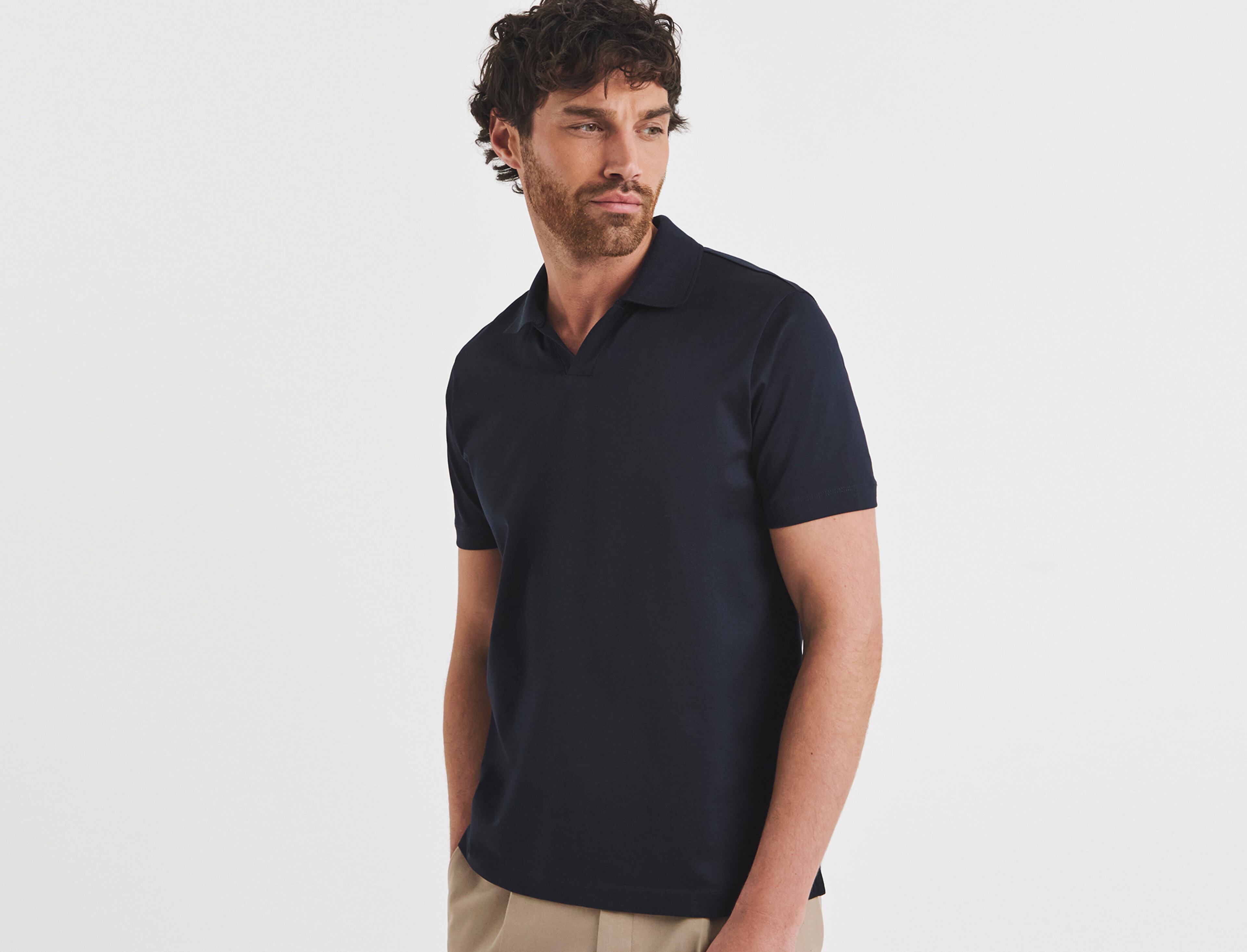 A man stood wearing a navy polo shirt