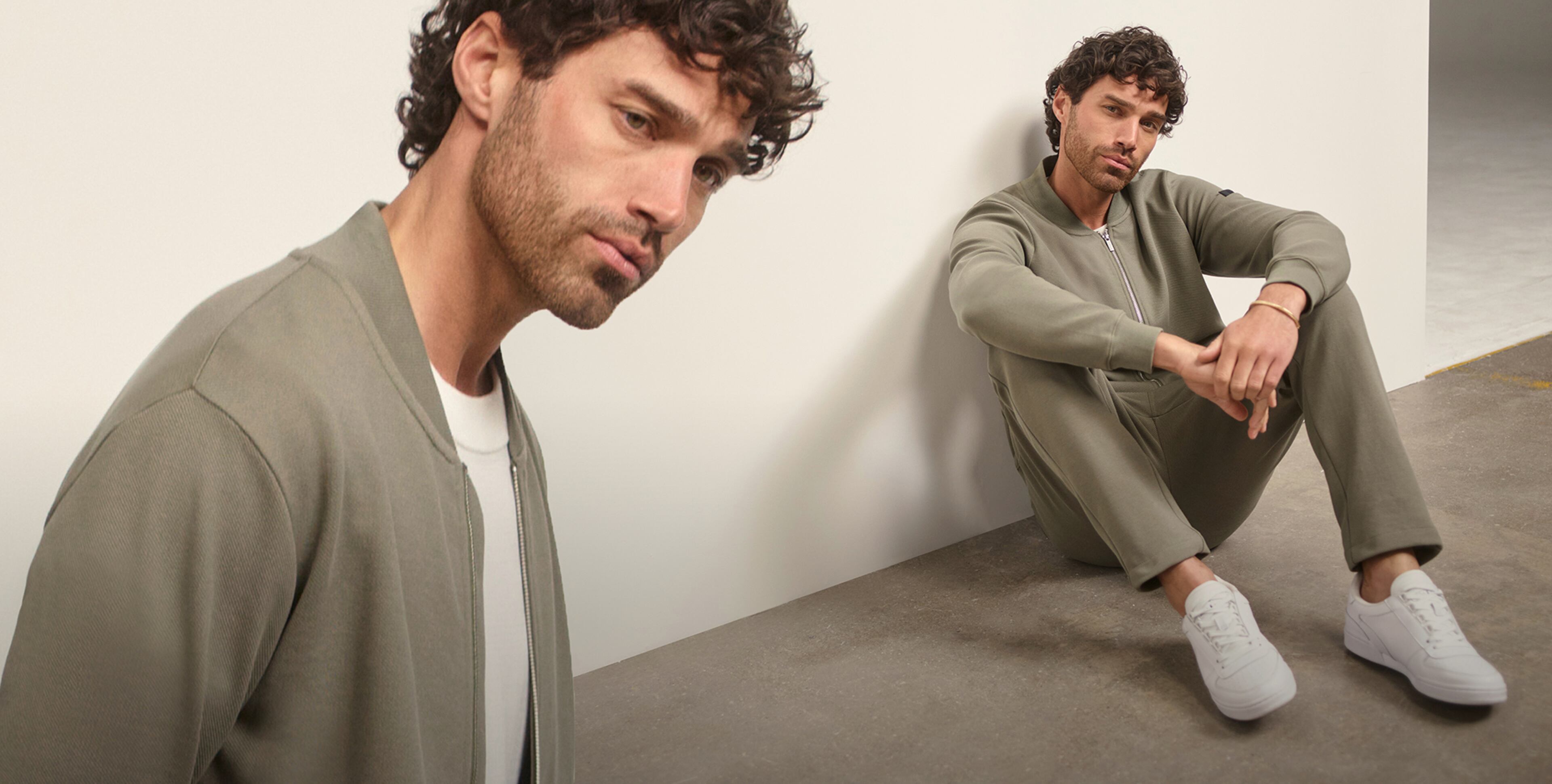 Man sat wearing a khaki cardigan and trousers